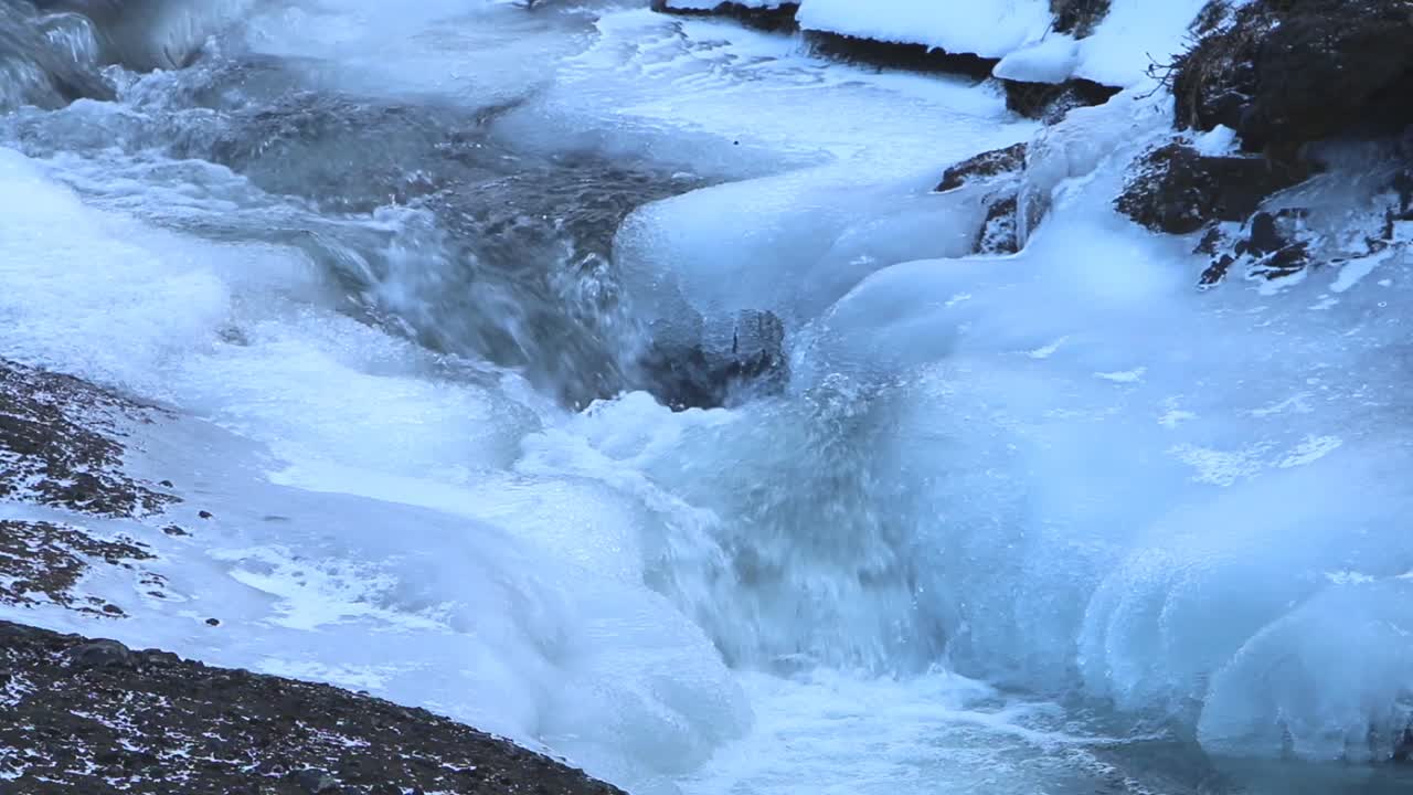 얼음으로 인 바위 위를 흐르는 빠르게 흐르는 강