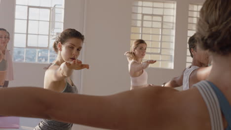 yoga class instructor teaching reverse warrior pose to beautiful group of women enjoying healthy lifestyle exercising in fitness studio at sunrise