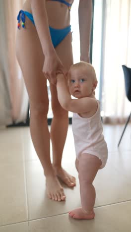 mother helping baby to walk