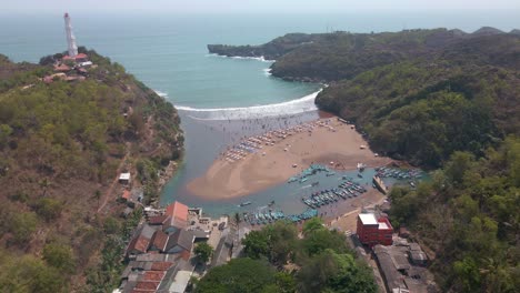 Aerial-drone-video-of-tropical-bay-and-sandy-beach-with-cliff-shoreline-and-lighthouse-on-the-top-of-it