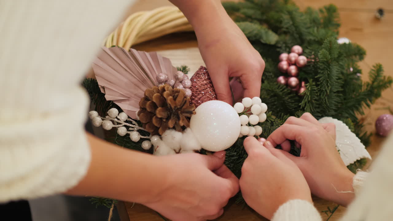 mujer con niño arregla joyas en corona de navidad 1
