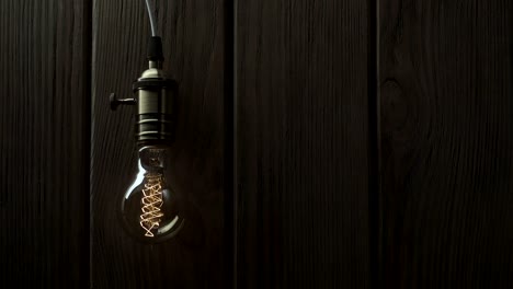 la bombilla se enciende lentamente, parpadea rápidamente en un fondo de madera