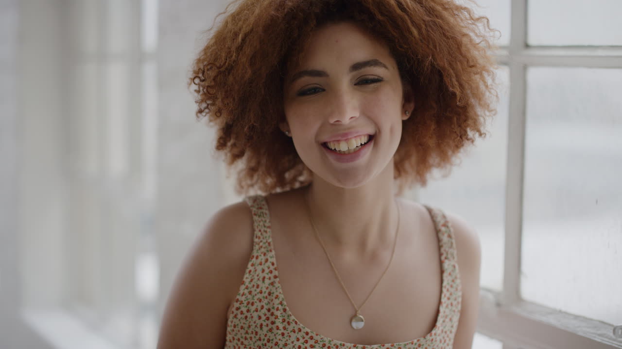 retrato de una mujer joven de raza mixta riendo alegremente disfrutando de un estilo de vida relajado e independiente estudiante excitada en su nuevo apartamento