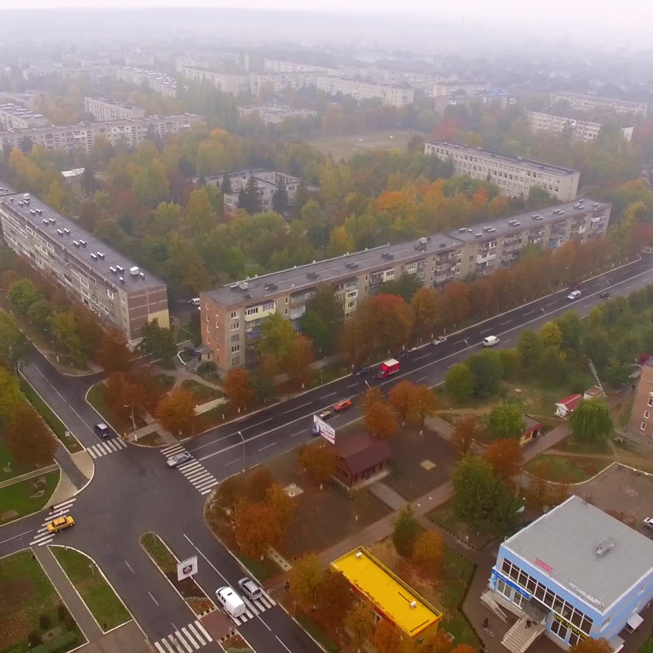 Crossroads with few cars in the city. Top view of the usual Ukrainian city on foggy autumn day