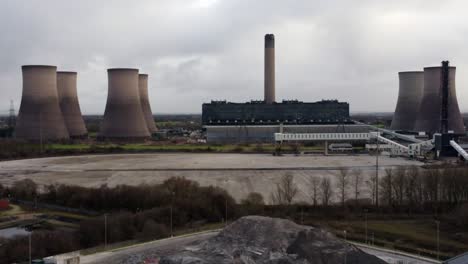 Aerial-view-slow-zoom-out-across-coal-fired-power-station-smokestack-site,-Fiddlers-Ferry-overcast-skyline