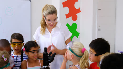 maestro ayudando a los niños en el laboratorio
