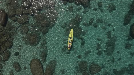 disparo aéreo descendiendo sobre un hombre tomando el sol en un kayak