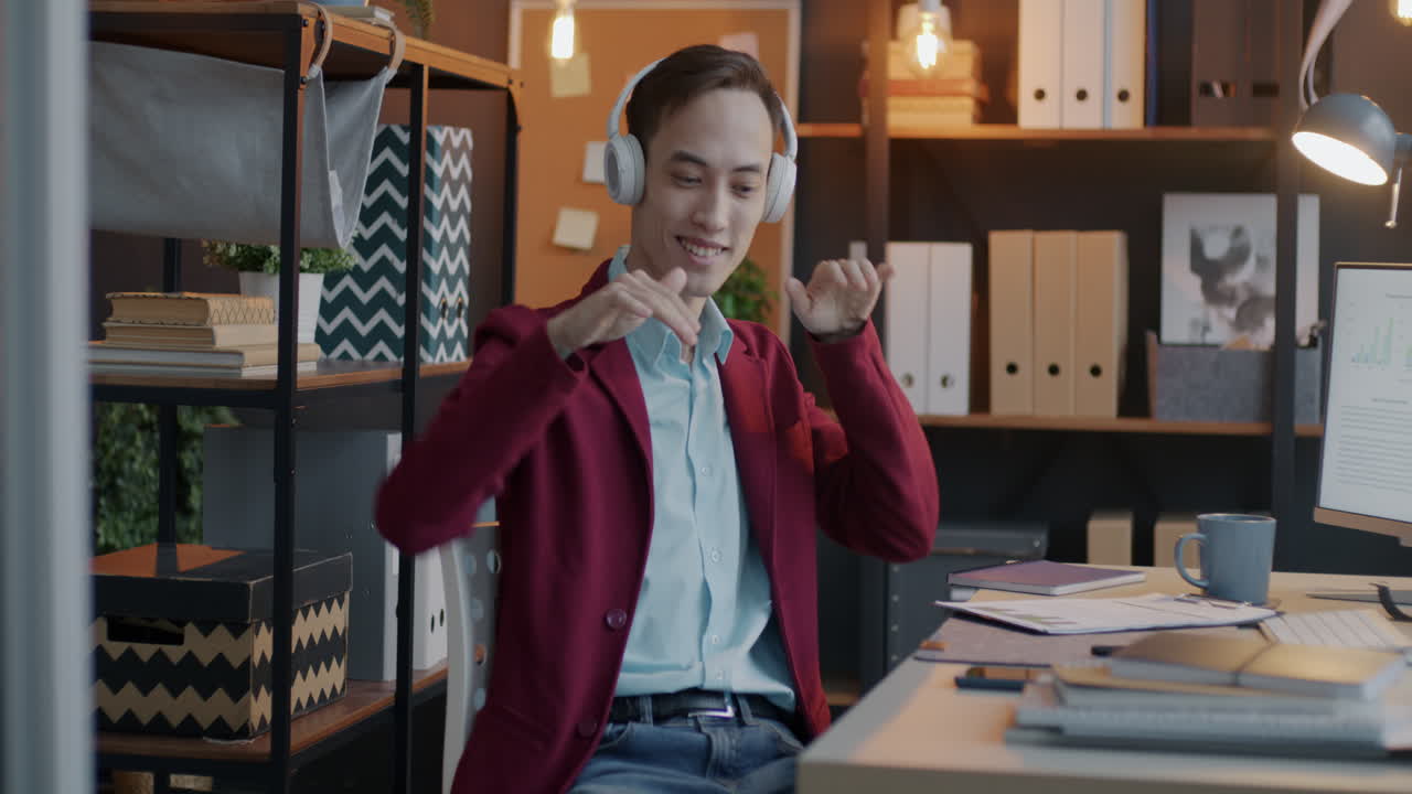 Happy Businessman Listening to Music and Dancing in Office
