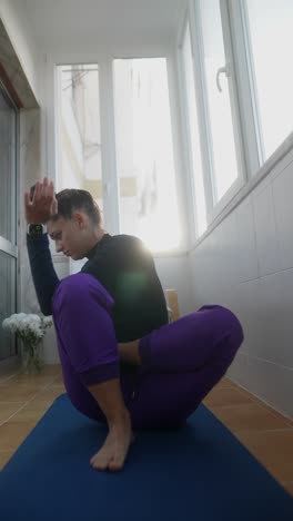 mujer practicando yoga en un balcón