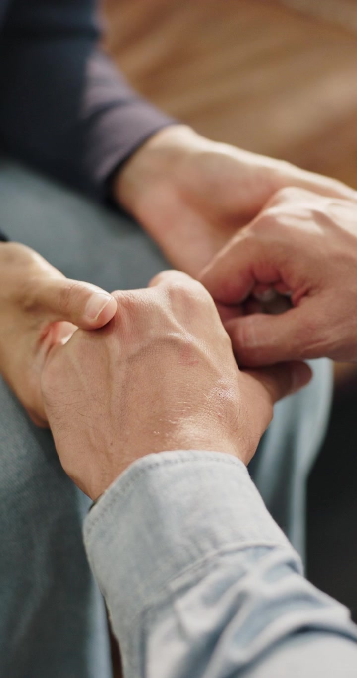 Primo piano di due persone che si tengono per mano per conforto e supporto
