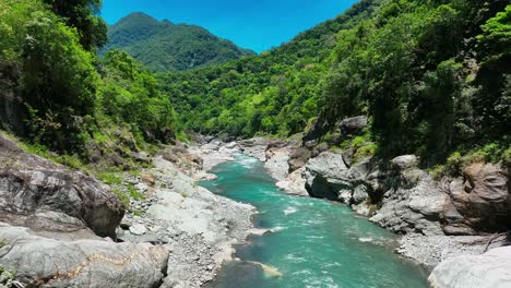 aerial flight over idyllic river flowing between green hills in taroko nationalpark in taiwan