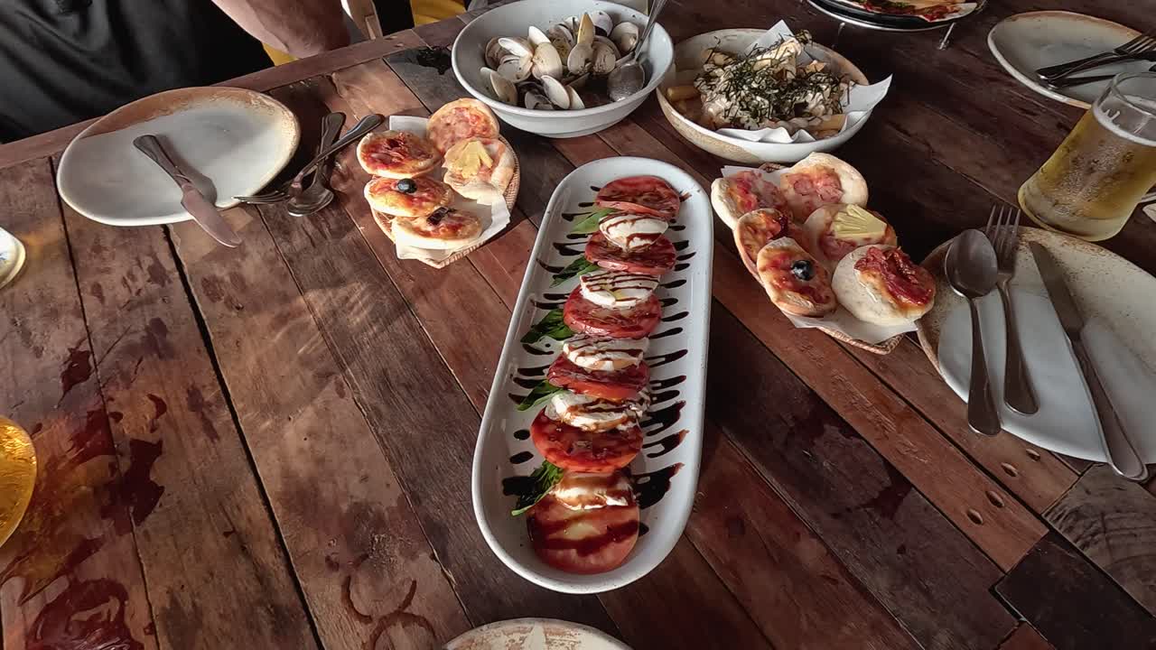 A rustic table in Phuket, Thailand, showcasing Italian-Thai seafood fusion dishes with natural lighting and a relaxed atmosphere