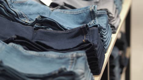stacks of folded denim jeans in various shades of blue