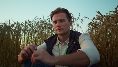 Portrait-serious-farmer-posing-at-cultivated-wheat-field.-Tired-man-rest-alone.