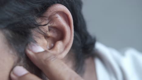 closeup of a person touching their ear