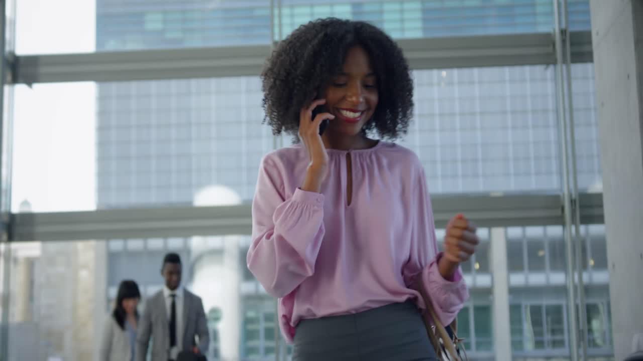 Businesswoman using mobile phone on escalator in a modern office 4k