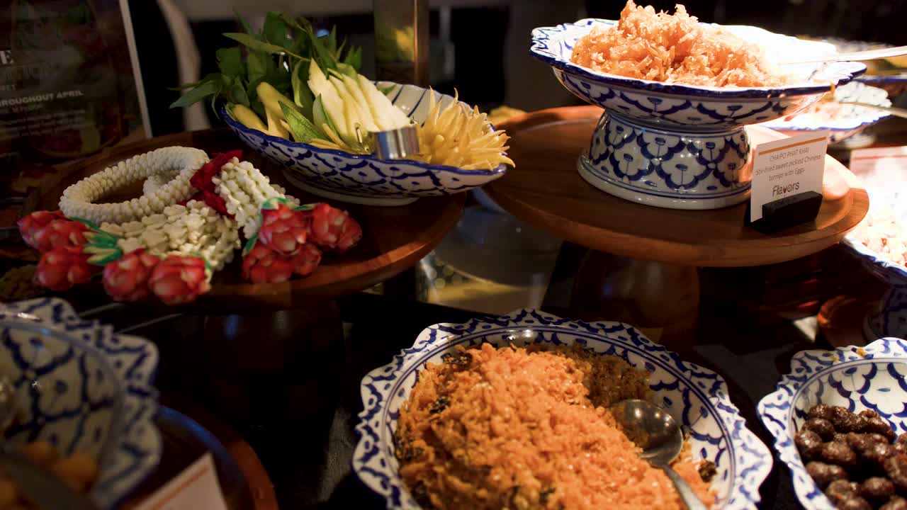 La telecamera scorre su contorni tradizionali thailandesi Khao Chae serviti in ciotole di ceramica blu e bianca