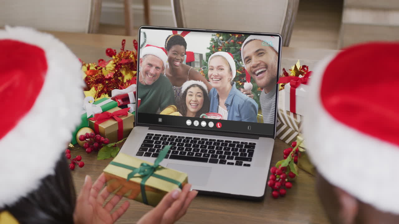 pareja diversa teniendo videoconferencia de navidad con personas diversas