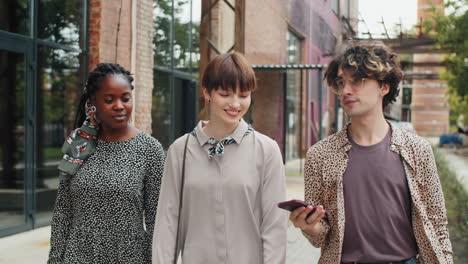 young multiethnic friends walking with shopping bags and chatting