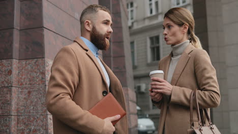 caucasian businessman and businesswoman talking and drinking coffee in the street in autumn, then african american man approachs to them