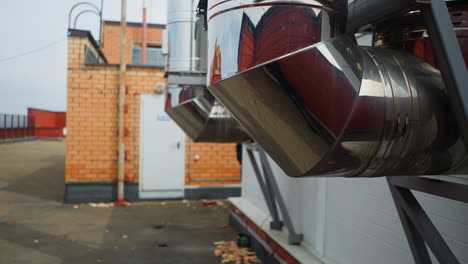 tubos de salida de ventilación metálicos brillantes en un primer plano del techo del edificio