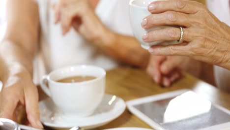 mujer mayor tomando café mientras charla con amigos 4k