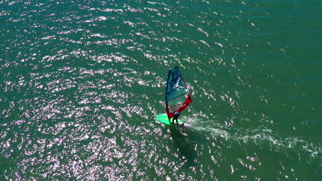 windsurfista surfeando y tratando de encontrar condiciones de viento perfectas, tiro aéreo