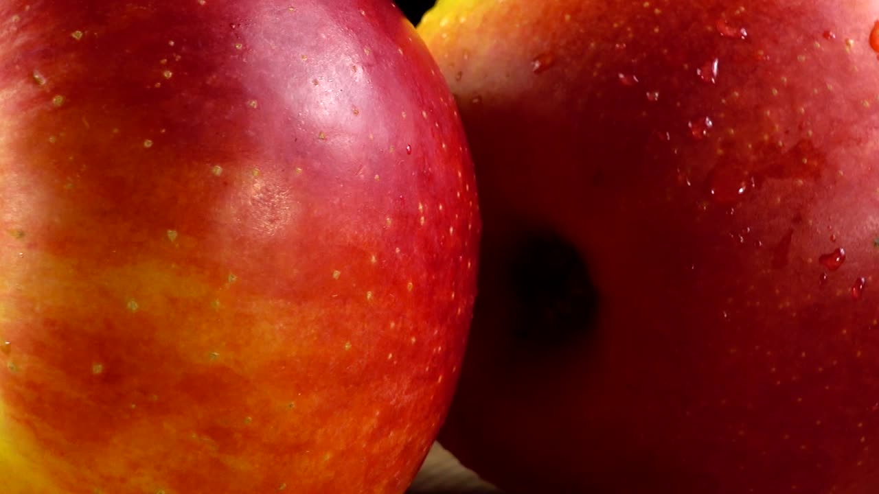 Apples on a black background. Cutting board in the movement