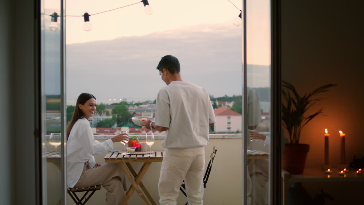 enamorados casados comiendo en la terraza de cerca. hombre amable trayendo comida a su esposa