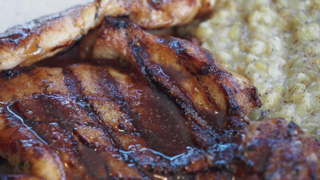 Close-up of Delicious Grilled Ribs with a Creamy Side Dish