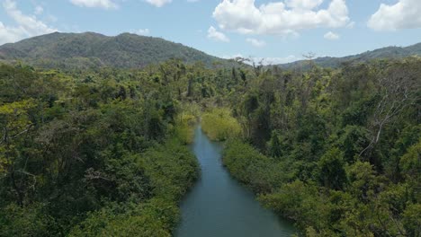 Ascending-panorama-view-of-idyllic-Rio-San-Juan-River-surrounded-by-idyllic-Rainforest-and-mountains-during-sunlight---Samana,-Dominican-Republic