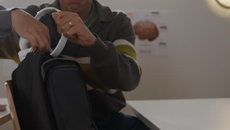 a person putting headphones into a backpack