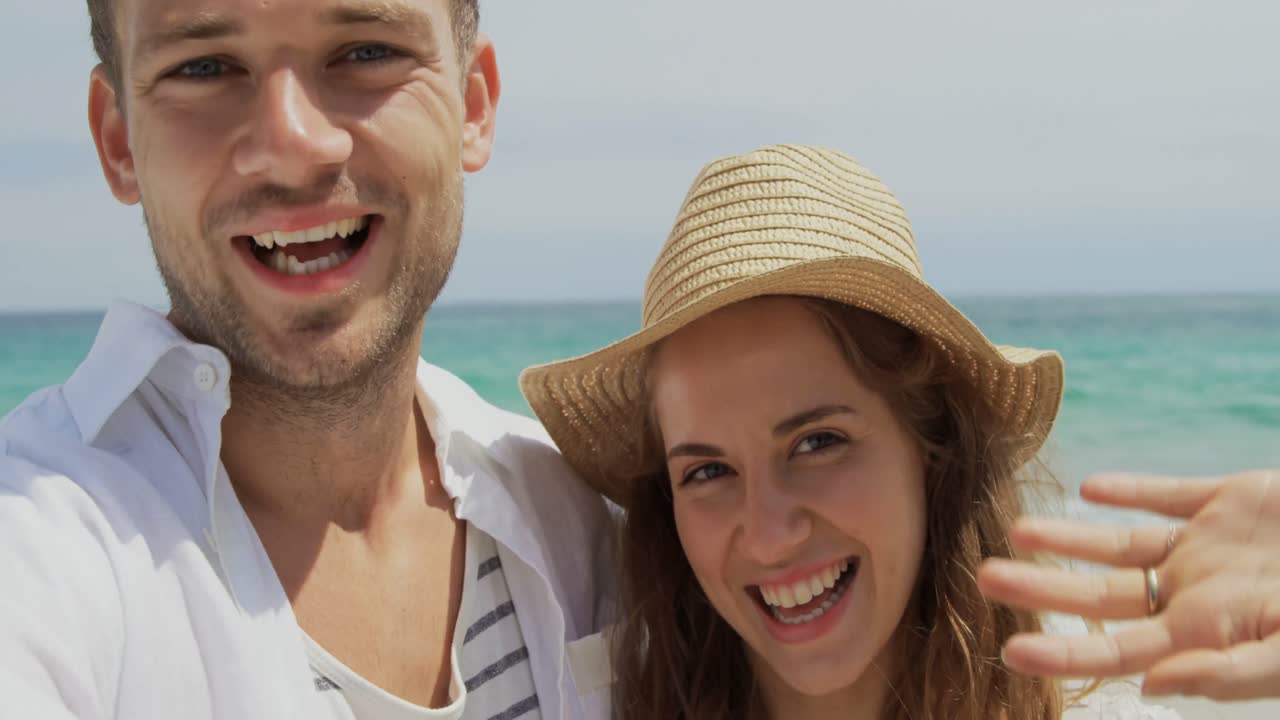 vista frontal de una pareja caucásica divirtiéndose en la playa 4k
