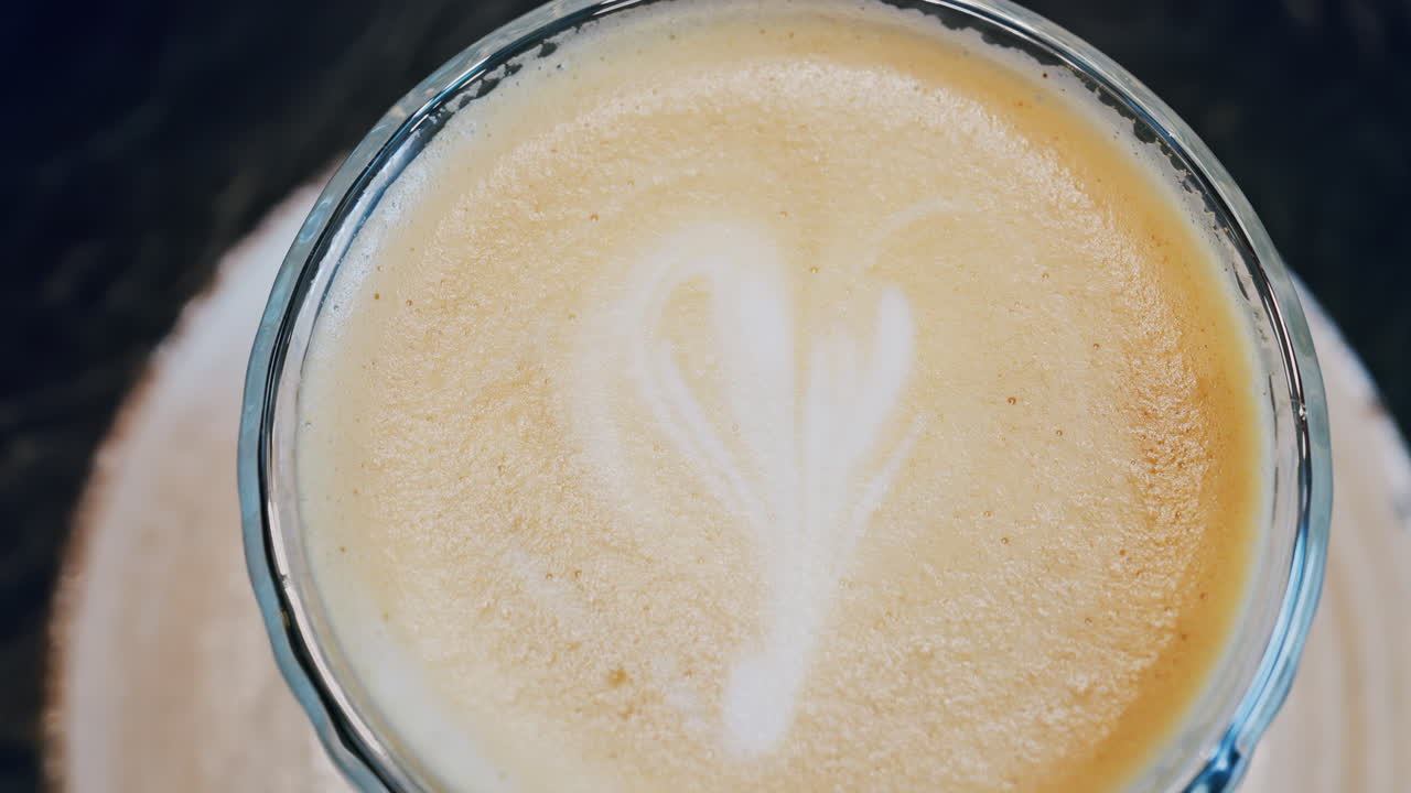 Close up of a glass cup with a latte at a cafe