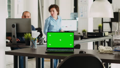 laptop with greenscreen display on desk