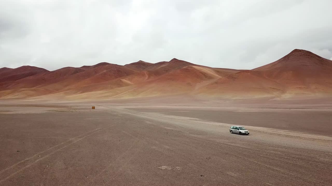 Aerial View of Lonely Vehicle on Dusty Road on Slopes of Atacama Desert, Chile