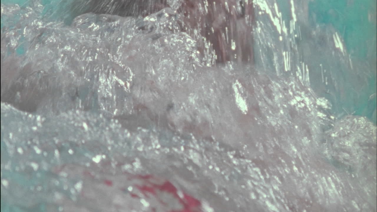 한 남자가 수영장을 가로질러 백 스트로크