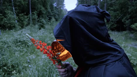 grim reaper with fiery animal skull breathing life to lupine flower in the wilderness