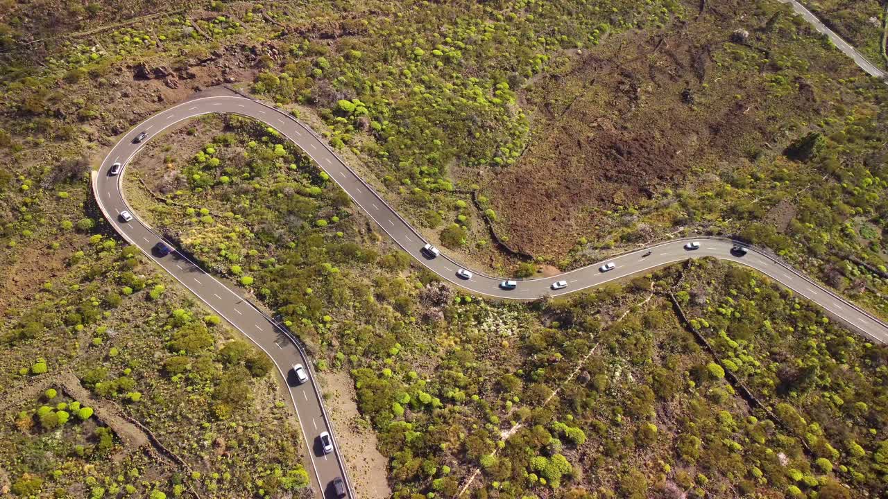 coches conduciendo por una carretera de montaña con curvas en la isla de tenerife, vista aérea de arriba hacia abajo