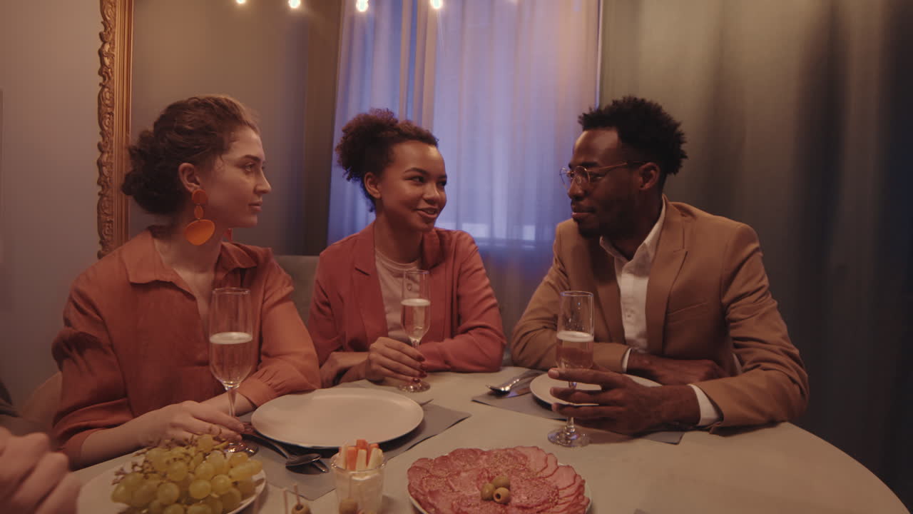 People Toasting with Champagne Glasses at Dinner Party