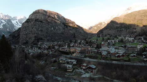 fpv drone antena en alpine resort courmayeur, valle de aosta, italia al pie de los alpes mont blanc monte bianco, volando sobre casas y árboles