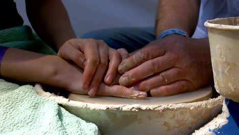 hands of the master potter and vase of clay on the potter's wheel close-up