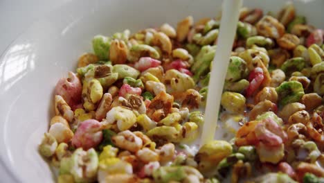 milk being pour into breakfast cereals bowl 4k