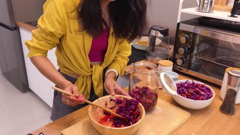 woman preparing fermented red cabbage salad