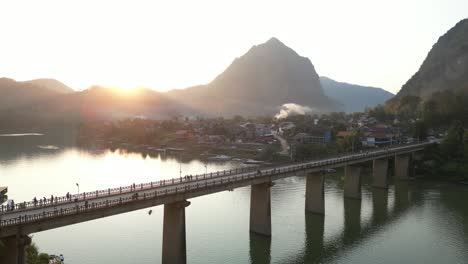 fotografía de un avión no tripulado de un puente de dos carriles al atardecer en la ciudad montañosa de nong khiaw en laos, asia sureste