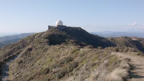 a radar dome on top of a tall hill overlooking a beautiful landscape