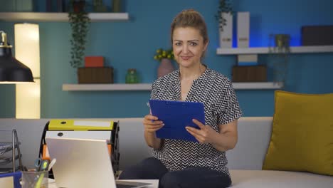 La-Mujer-Trabajadora-De-Oficina-En-Casa-Sonríe-A-La-Cámara.