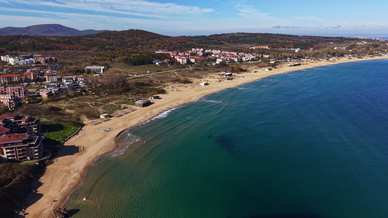 Vista serena della spiaggia che cattura la costa tranquilla e le onde delicate sotto un cielo sereno in un'idilliaca località balneare durante il giorno