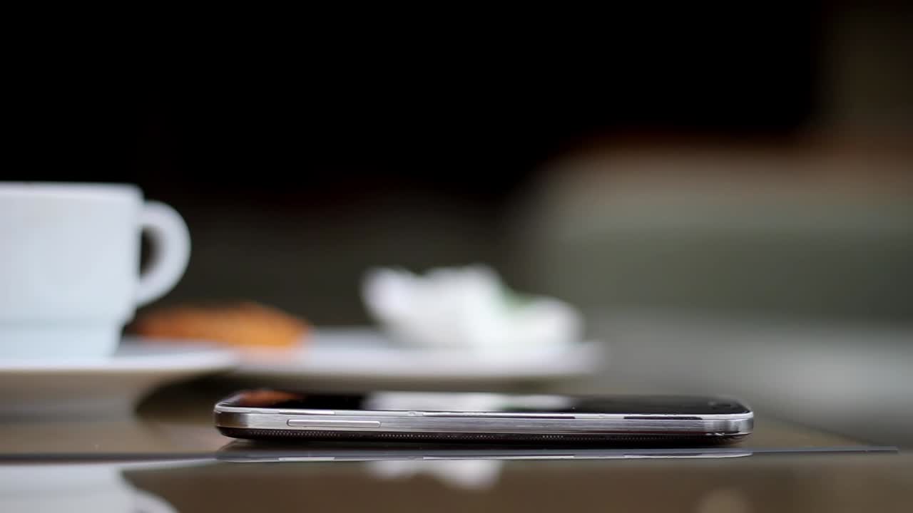 joven usando su teléfono inteligente en un café cerca de las manos 6
