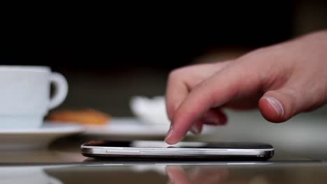 Young-Man-Using-His-Smartphone-In-A-Cafe-Close-Up-Hands-6